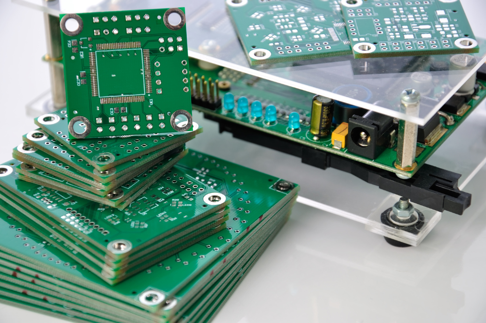 A stack of electronic components on a table, showcasing parts for box build PCB assembly.
